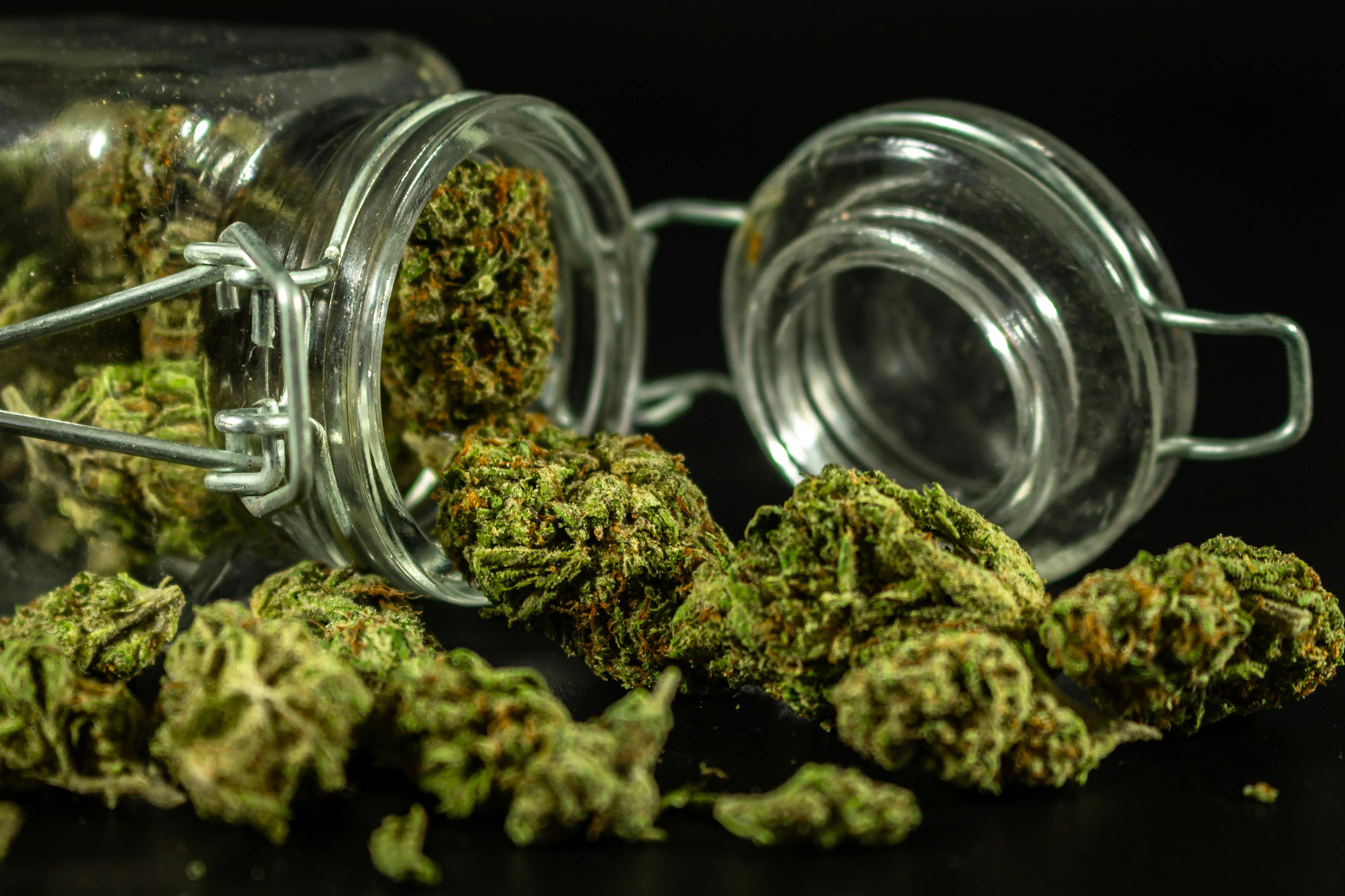 Glass jar of top-shelf THCa flower buds from StreetStem displayed on a dark background.